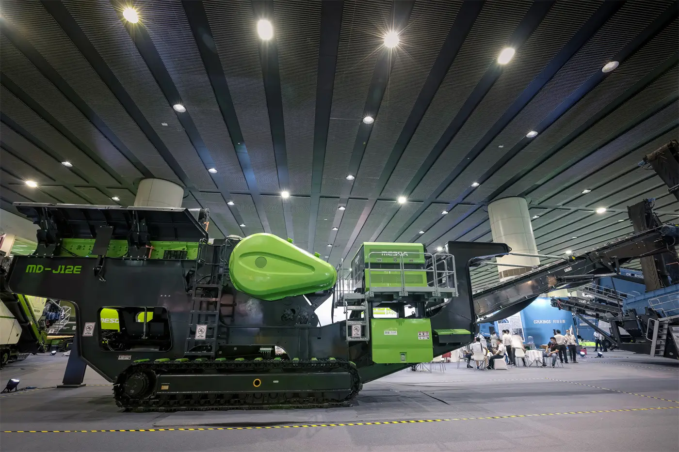 Tracked jaw crusher producing base material on a civil construction site.