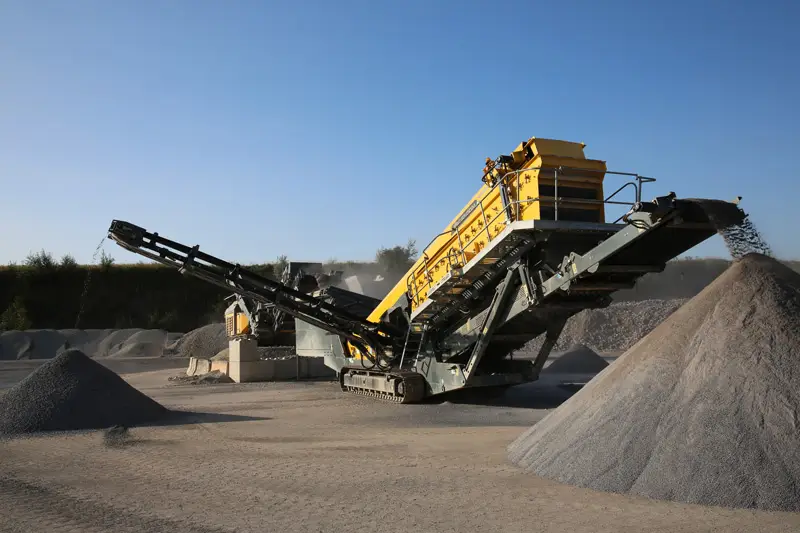 Yellow Rubble Master mobile impact crusher discharging crushed aggregate at an Australian quarry.