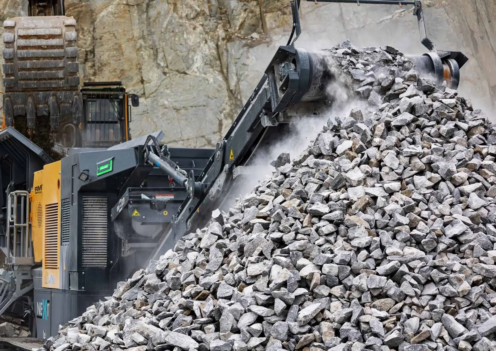 Rubble Master RM J110X mobile jaw crusher crushing rock at a quarry face.