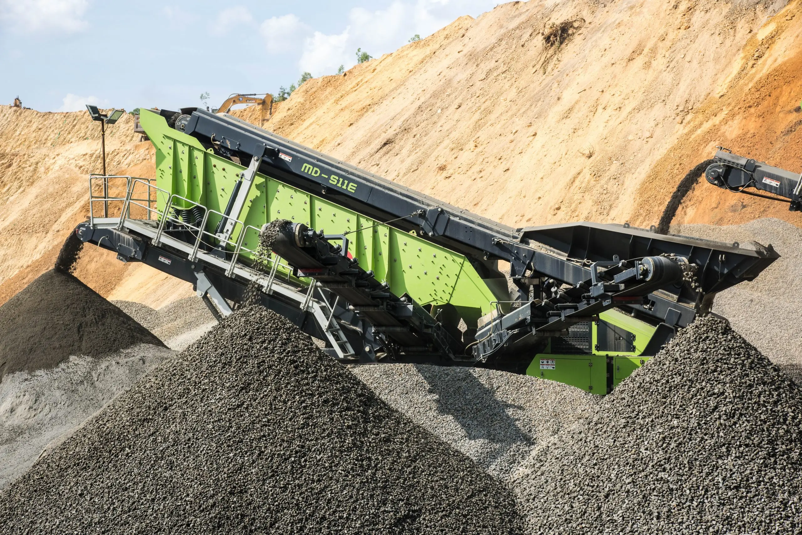 Green tracked screener in front of mounded earth at an Australian quarry.